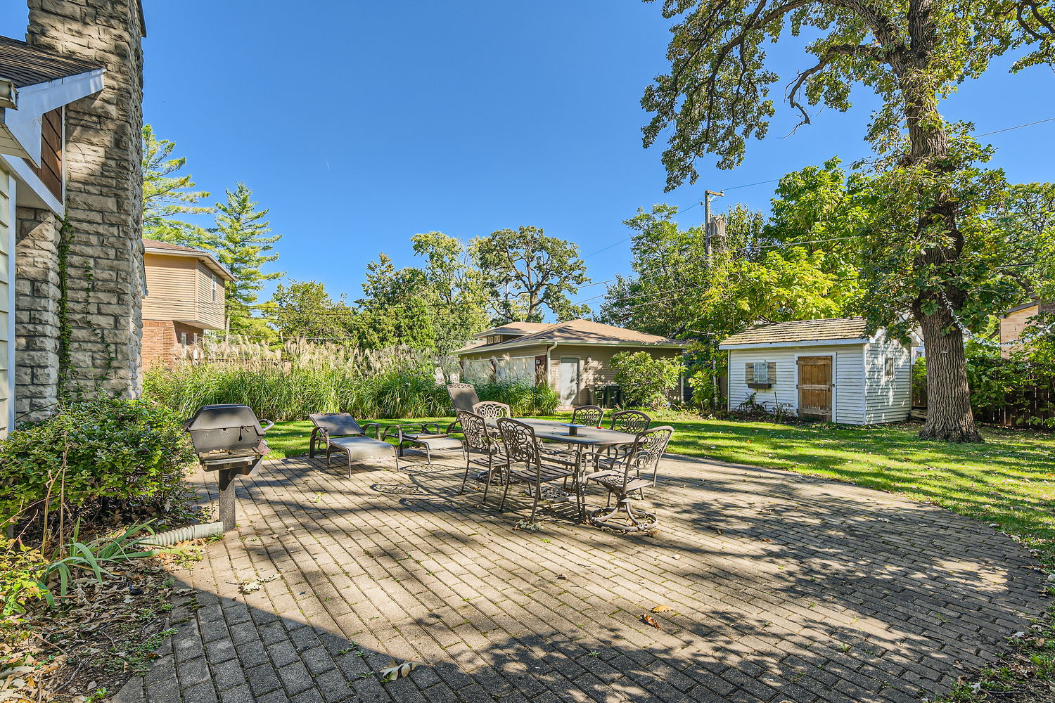207 Scottswood Road Riverside, IL 60546 - Photo 27 of 32 a row of tables and chairs under an umbrella in front of house