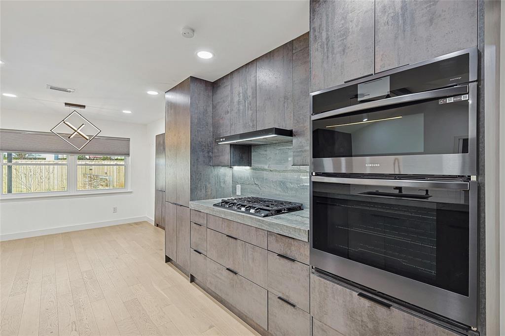 12417 Quincy Lane Dallas, TX 75230 - Photo 18 of 40 a kitchen with granite countertop a stove and a microwave oven