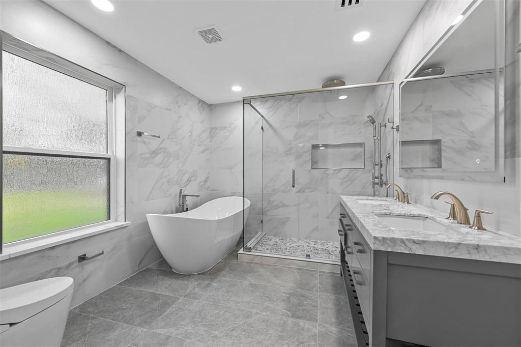 12417 Quincy Lane Dallas, TX 75230 - Photo 21 of 40 a bathroom with a granite countertop sink mirror toilet and bathtub