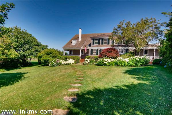 7 Starbuck Neck Road Edgartown, MA 02539 - Photo 11 of 41 a front view of a house with a yard table and chairs