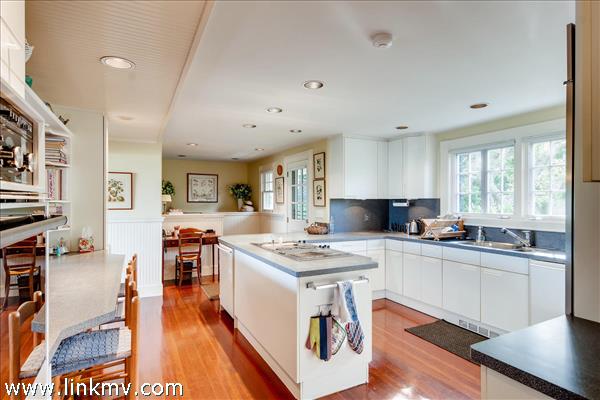 7 Starbuck Neck Road Edgartown, MA 02539 - Photo 27 of 41 a kitchen with stainless steel appliances granite countertop a stove top oven a sink dishwasher and white cabinets with wooden floor