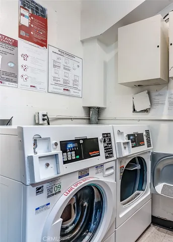 a utility room with stainless steel appliances washer and dryer