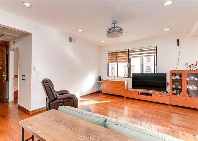 a living room with furniture a flat screen tv and a floor to ceiling window