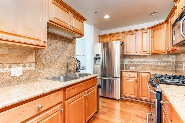 a kitchen with granite countertop a refrigerator and a sink