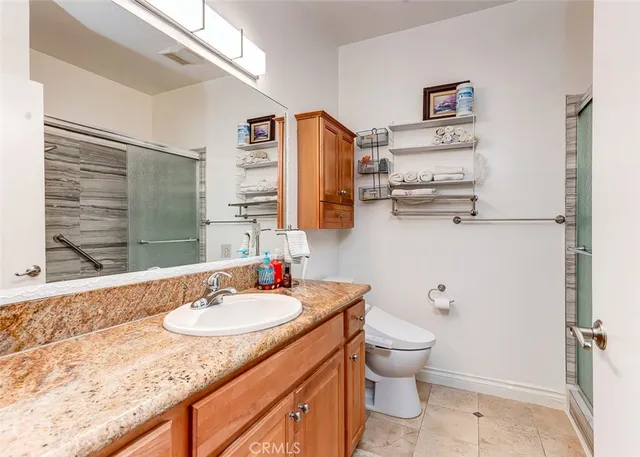 a bathroom with a granite countertop sink toilet and shower