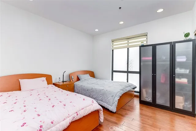 a bedroom with two beds and wooden floor