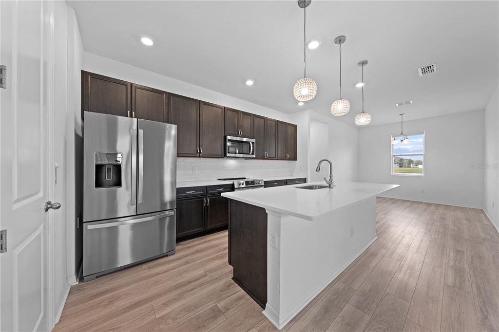 920 Livestock Loop St. Cloud, FL 34771 - Photo 13 of 55 a kitchen with stainless steel appliances a refrigerator sink and microwave