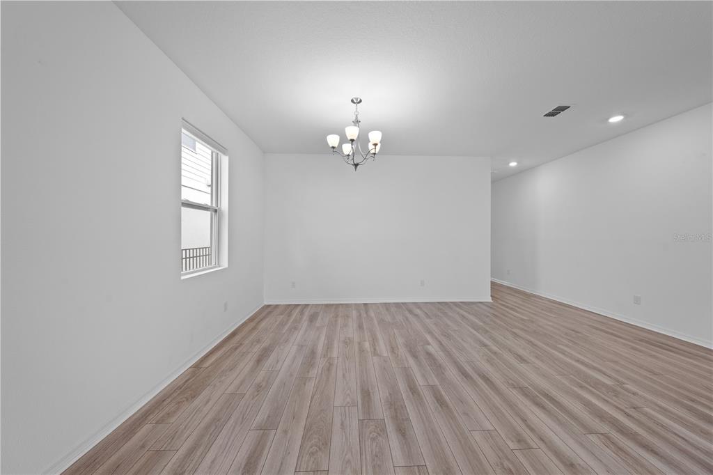920 Livestock Loop St. Cloud, FL 34771 - Photo 25 of 55 wooden floor in an empty room with a window