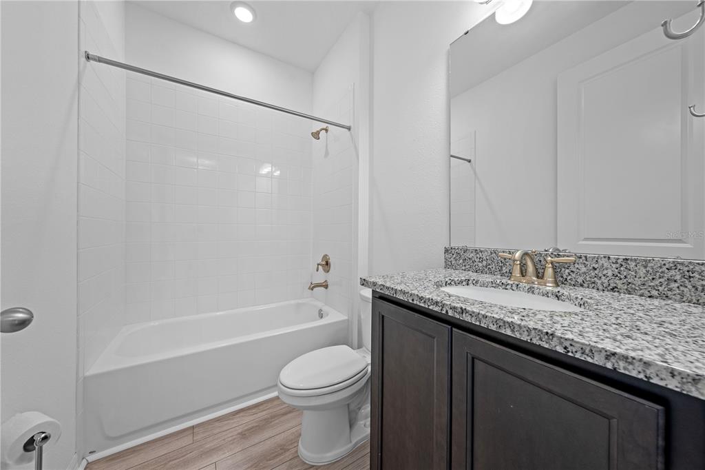 920 Livestock Loop St. Cloud, FL 34771 - Photo 34 of 55 a bathroom with a granite countertop sink toilet and shower