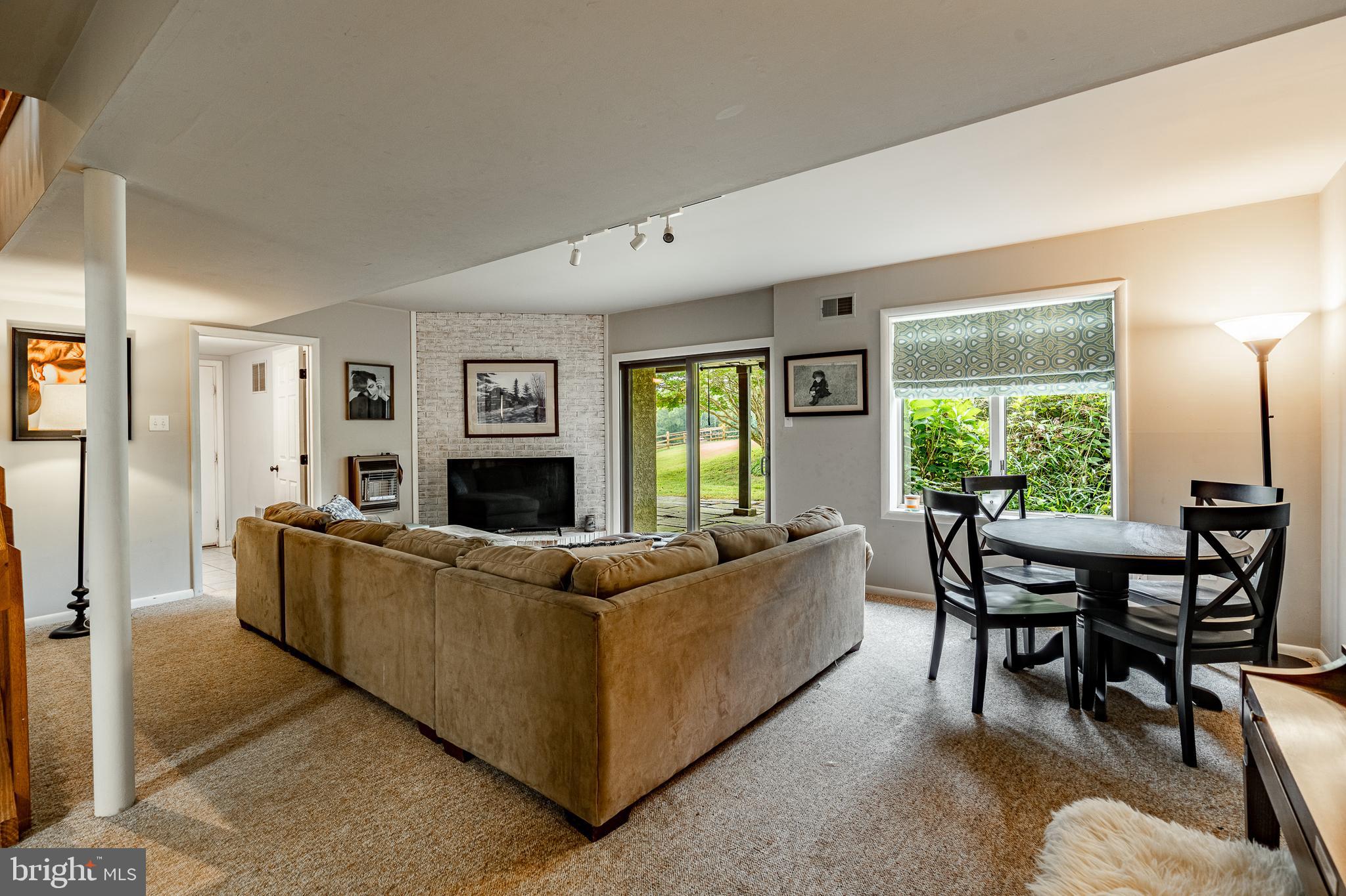 19 Ringfield Road, Unit 19 Chadds Ford, PA 19317 - Photo 28 of 39 a living room with furniture a large window and a fireplace