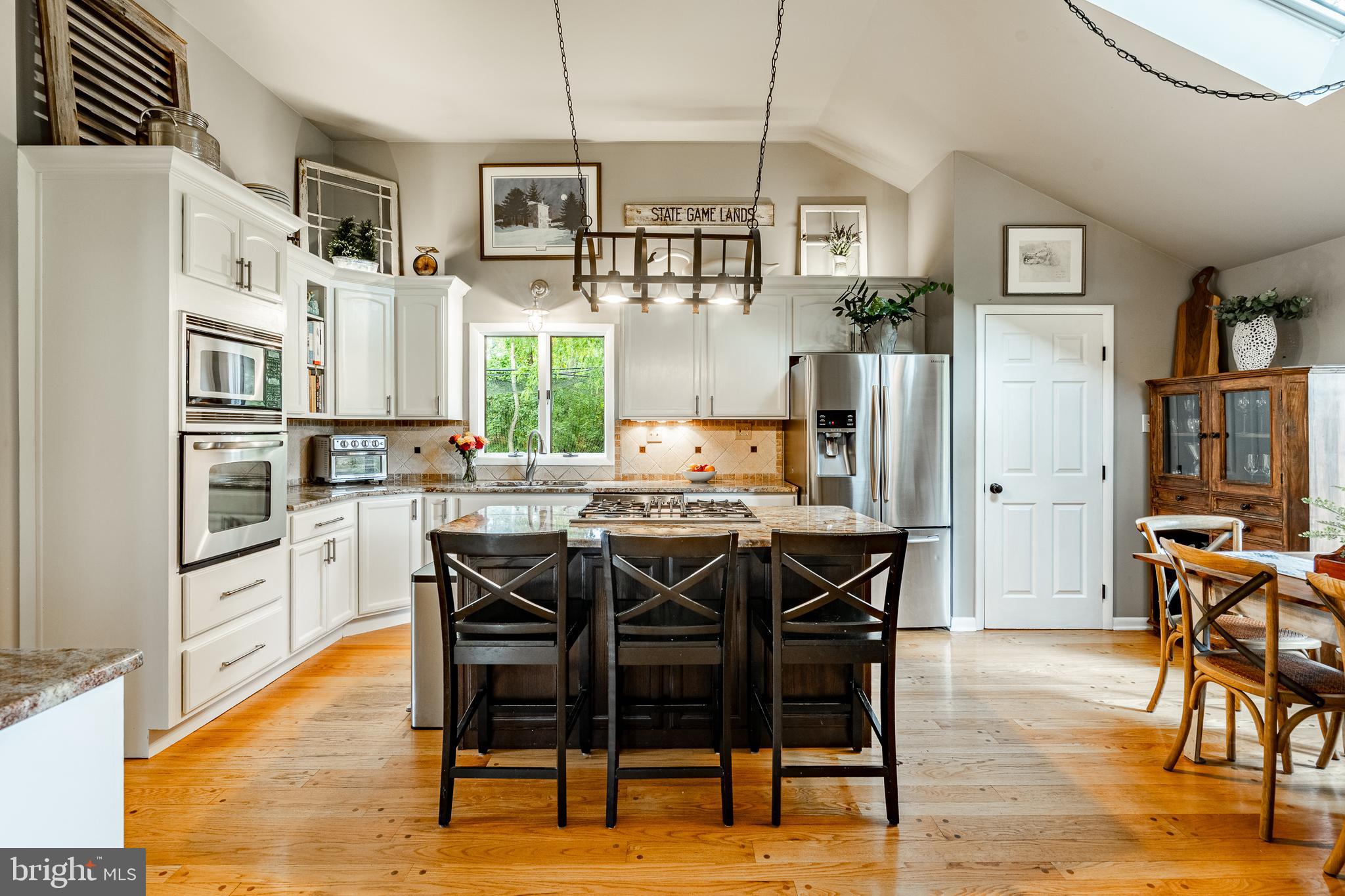 19 Ringfield Road, Unit 19 Chadds Ford, PA 19317 - Photo 10 of 39 a kitchen with stainless steel appliances granite countertop a dining table chairs refrigerator and sink