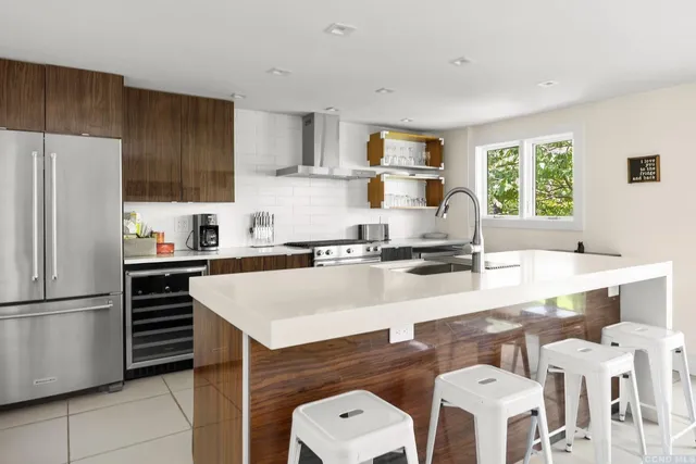 a kitchen with a sink a stove a refrigerator and white cabinets