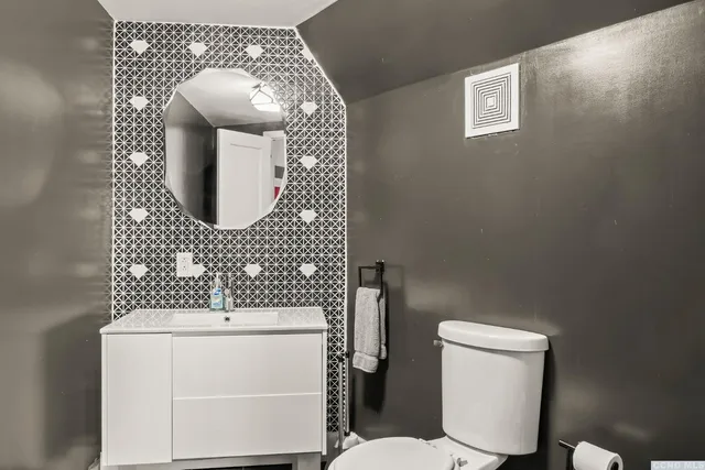 a bathroom with a toilet sink and mirror