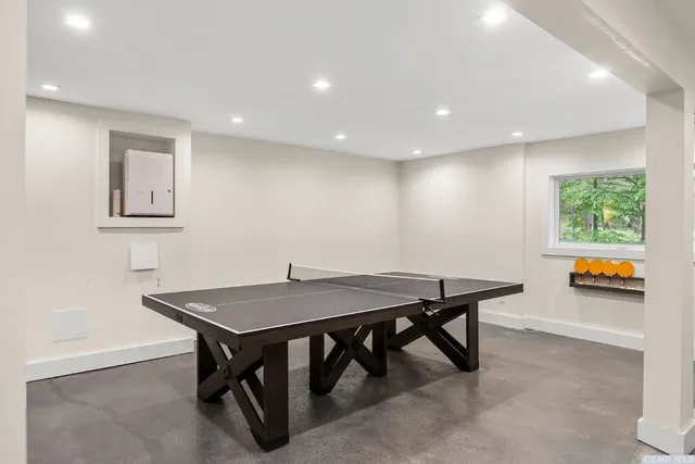 a living room with furniture a flat screen tv and a large window