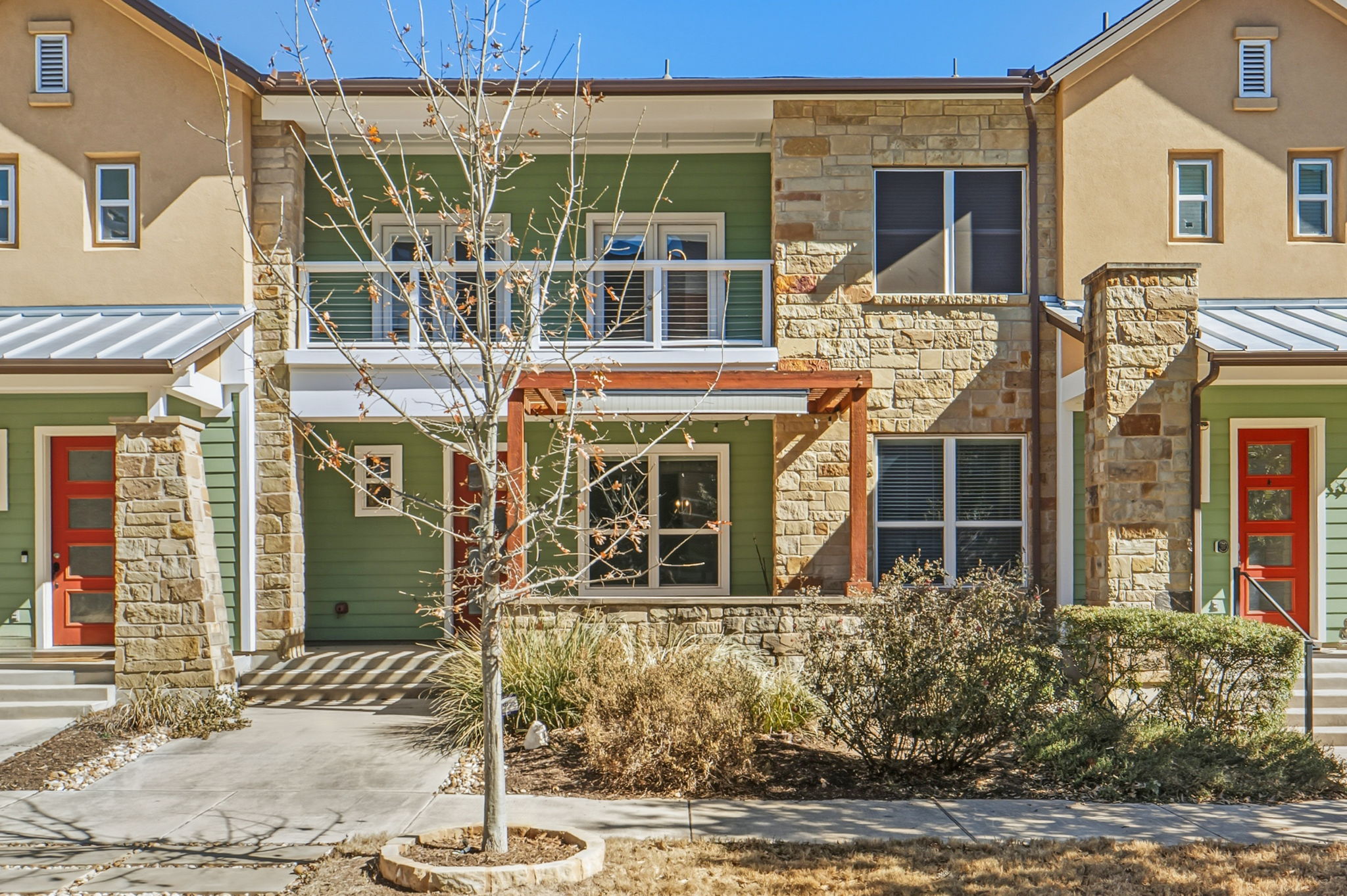 3919 Vaughan Street Austin, TX 78723 - Photo 2 of 40 Bold red entryways punctuate the natural stone and siding facade of these charming townhomes.