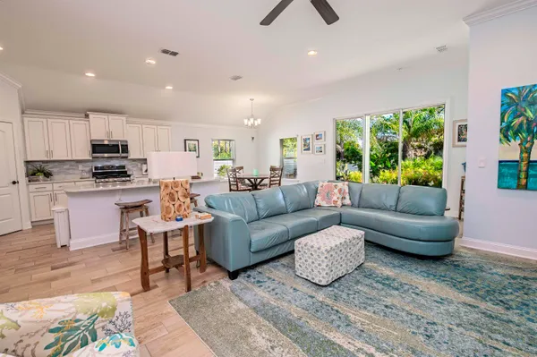 a living room with stainless steel appliances furniture and a view of kitchen