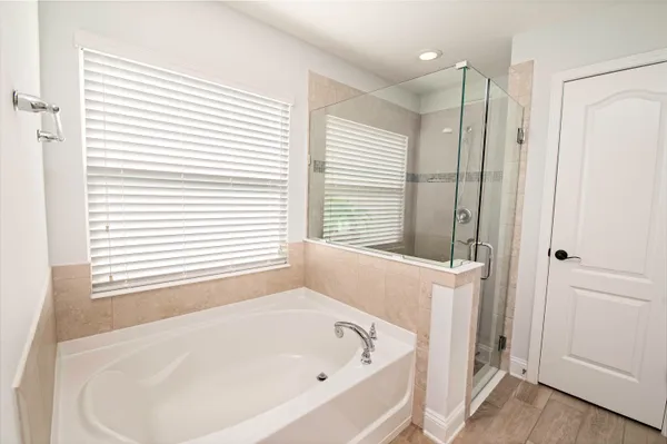 a white bath tub sitting in a bathroom next to a window