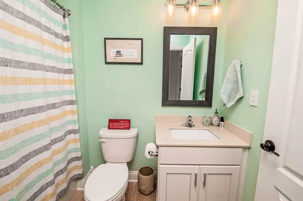 a bathroom with a toilet sink vanity and mirror