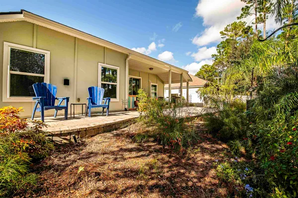 a view of a house with backyard and sitting area