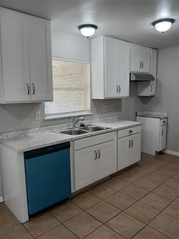 a kitchen with granite countertop white cabinets white stainless steel appliances with a sink and dishwasher