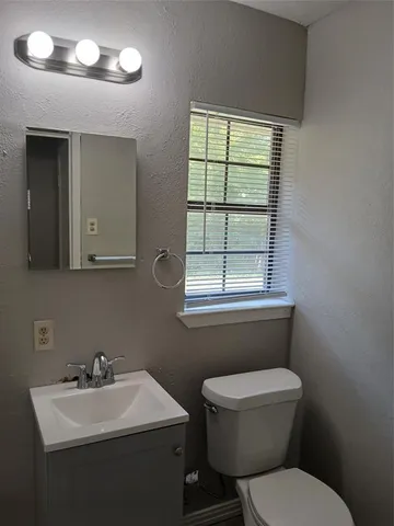 a bathroom with a toilet a sink and a window