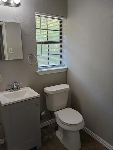 a bathroom with a toilet a sink and a window