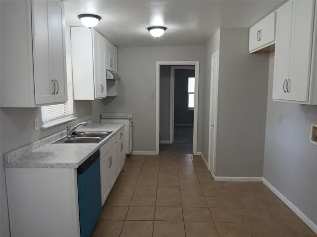 a kitchen with a stove sink and cabinets