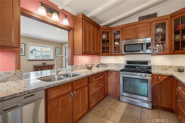 a kitchen with stainless steel appliances granite countertop a refrigerator a stove and a sink