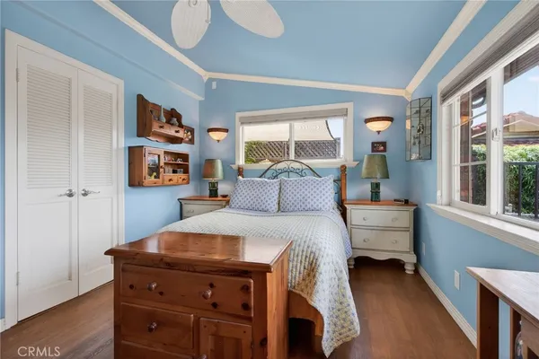 a bedroom with a bed and a bookshelf with a large window