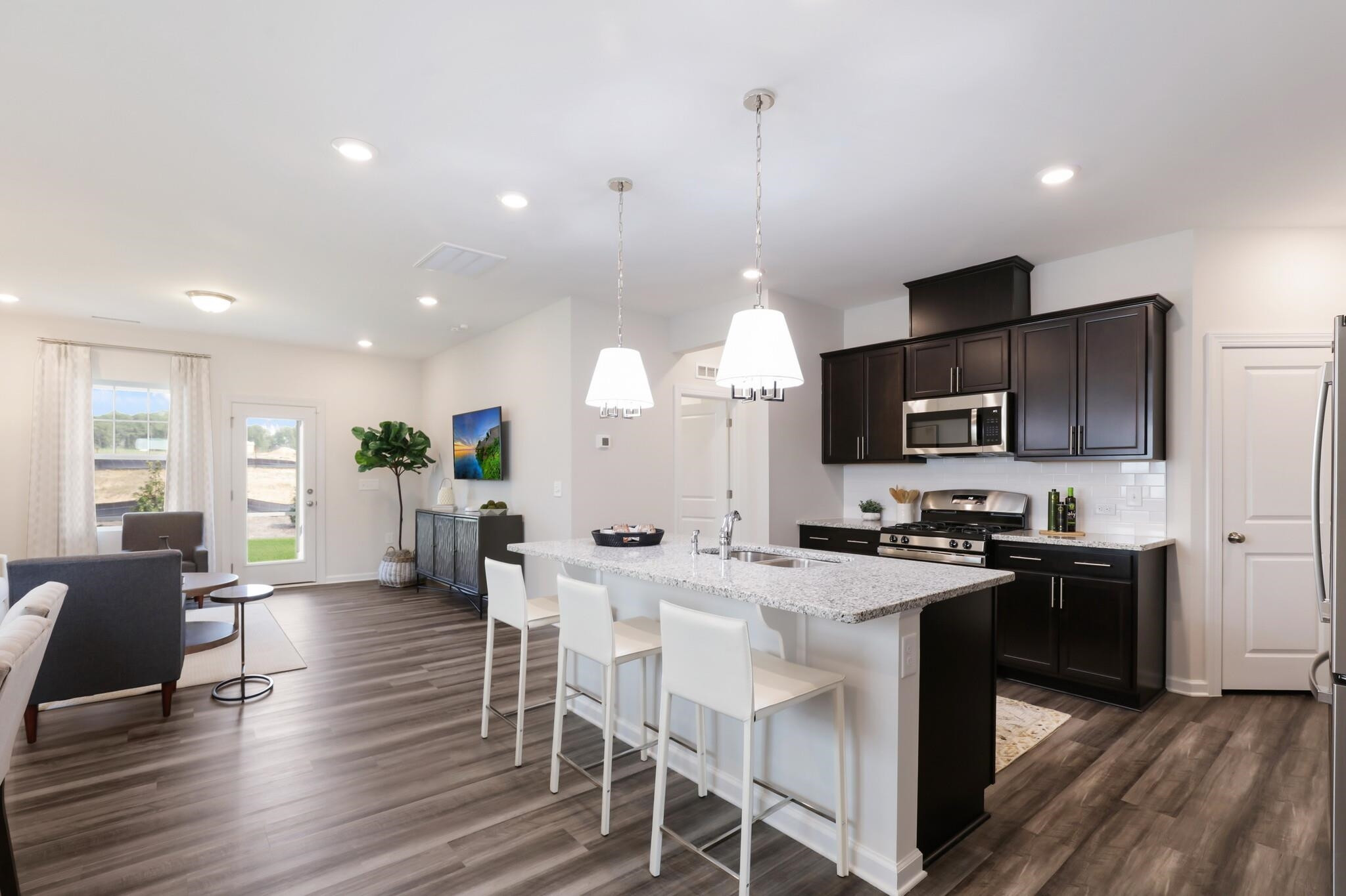 709 Spoonbill Trail Durham, NC 27703 - Photo 7 of 39 a kitchen with stainless steel appliances a dining table chairs stove refrigerator and cabinets