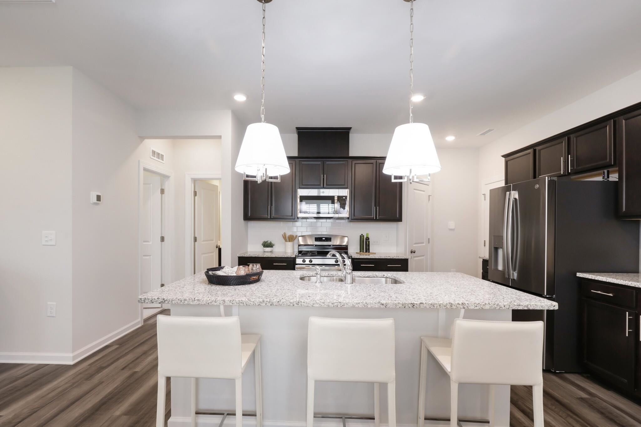 709 Spoonbill Trail Durham, NC 27703 - Photo 8 of 39 a kitchen with a dining table cabinets and refrigerator