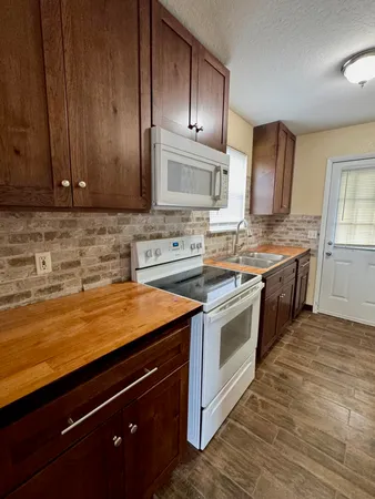 a kitchen with stainless steel appliances granite countertop a stove a sink and a microwave