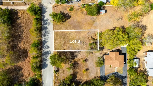 an aerial view of residential houses with outdoor space and trees