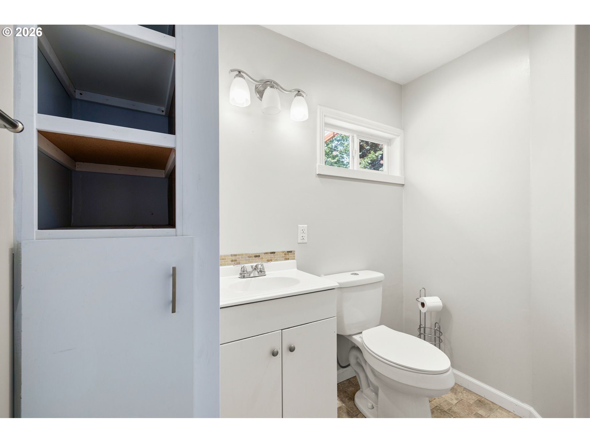 10245 Southeast Raymond Street Portland, OR 97266 - Photo 16 of 25 a bathroom with a toilet a sink and mirror