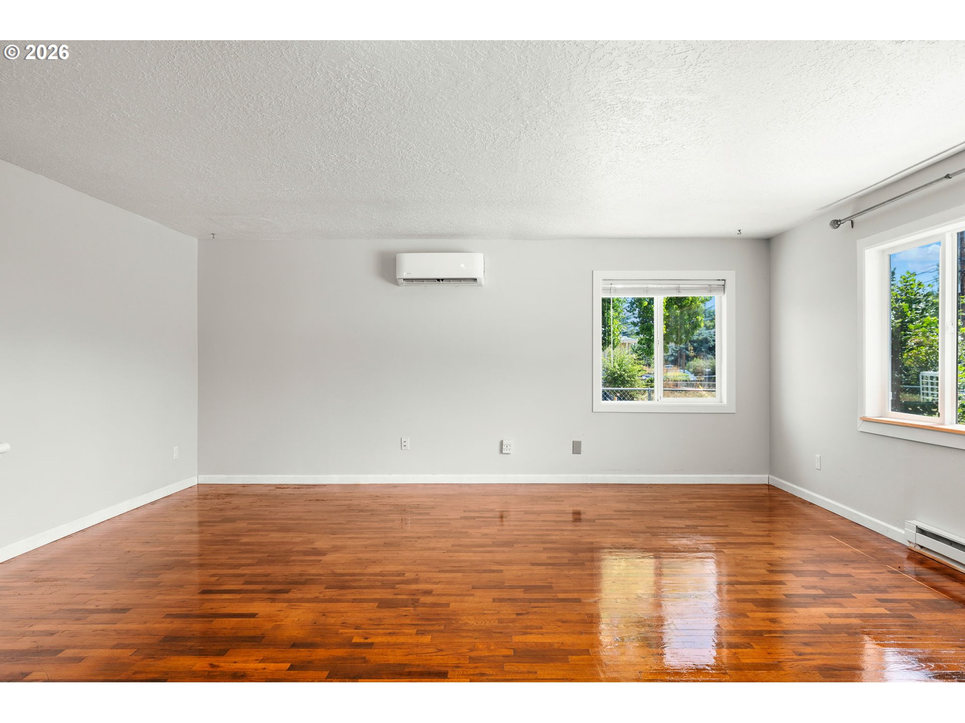 10245 Southeast Raymond Street Portland, OR 97266 - Photo 5 of 25 a view of an empty room with wooden floor and a window