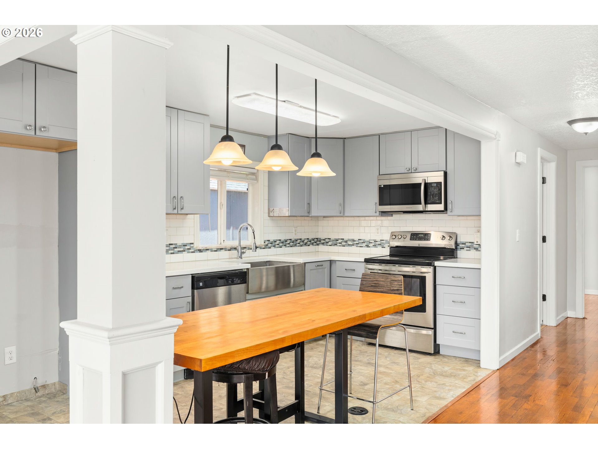 10245 Southeast Raymond Street Portland, OR 97266 - Photo 6 of 25 a kitchen with kitchen island granite countertop stainless steel appliances and a sink