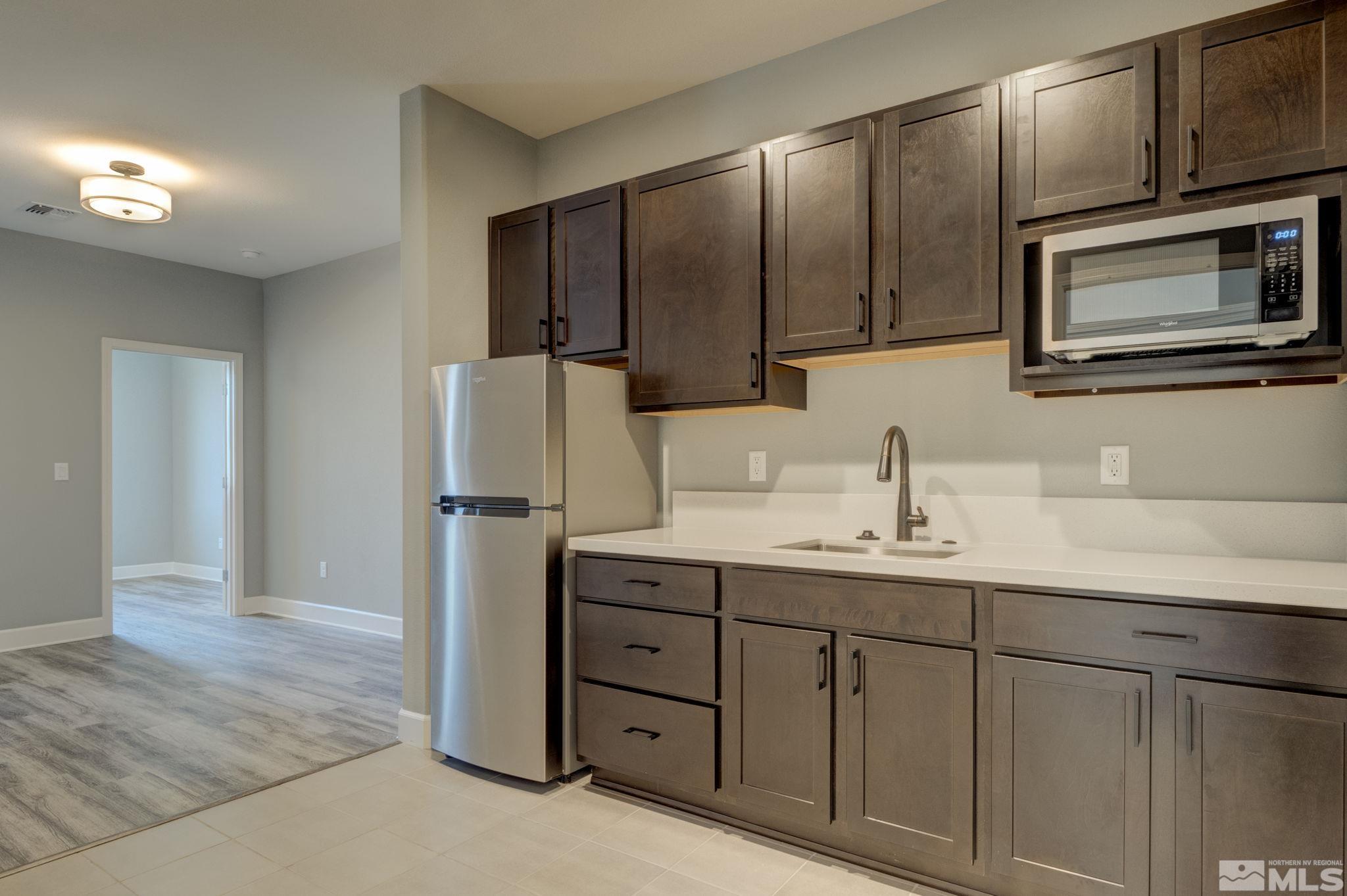 607 Riverbed Circle Reno, NV 89521 - Photo 16 of 40 a kitchen with stainless steel appliances granite countertop a refrigerator and cabinets