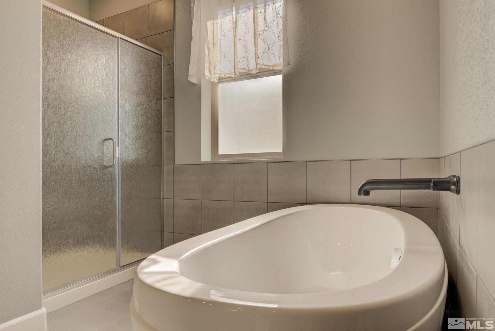 607 Riverbed Circle Reno, NV 89521 - Photo 28 of 40 a bathroom with a white bath tub and shower