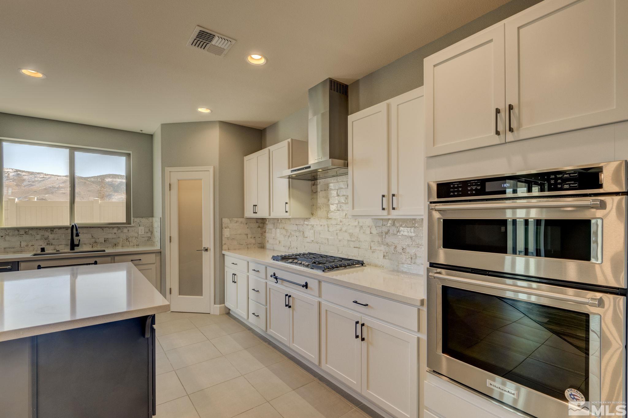 607 Riverbed Circle Reno, NV 89521 - Photo 7 of 40 a kitchen with stainless steel appliances granite countertop a stove and a sink