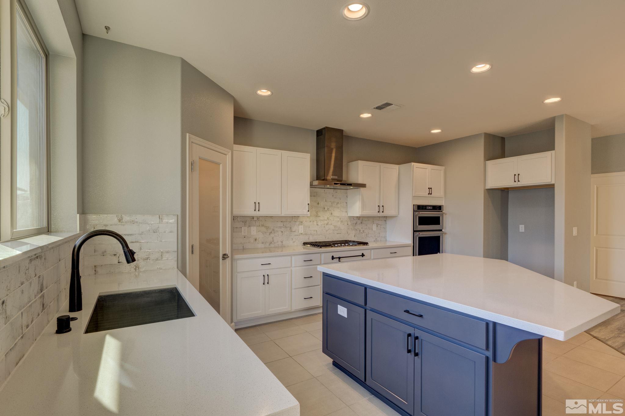 607 Riverbed Circle Reno, NV 89521 - Photo 9 of 40 a kitchen with kitchen island a sink stainless steel appliances and cabinets