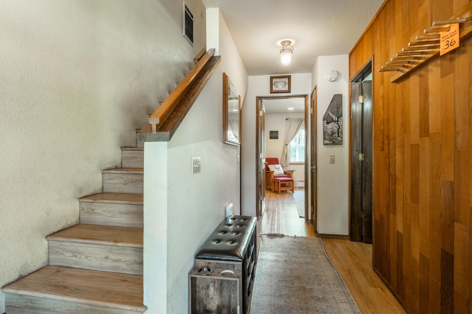 384 Joaquin Road, Unit 36 Mammoth Lakes, CA 93546 - Photo 31 of 36 Entryway featuring wood-finish flooring, a staircase with wooden handrails, and a hallway with verti