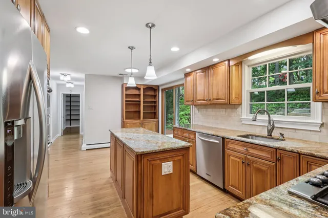 a kitchen with granite countertop stainless steel appliances a refrigerator and cabinets