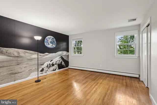 a bathroom with a granite countertop toilet a sink a mirror and a window