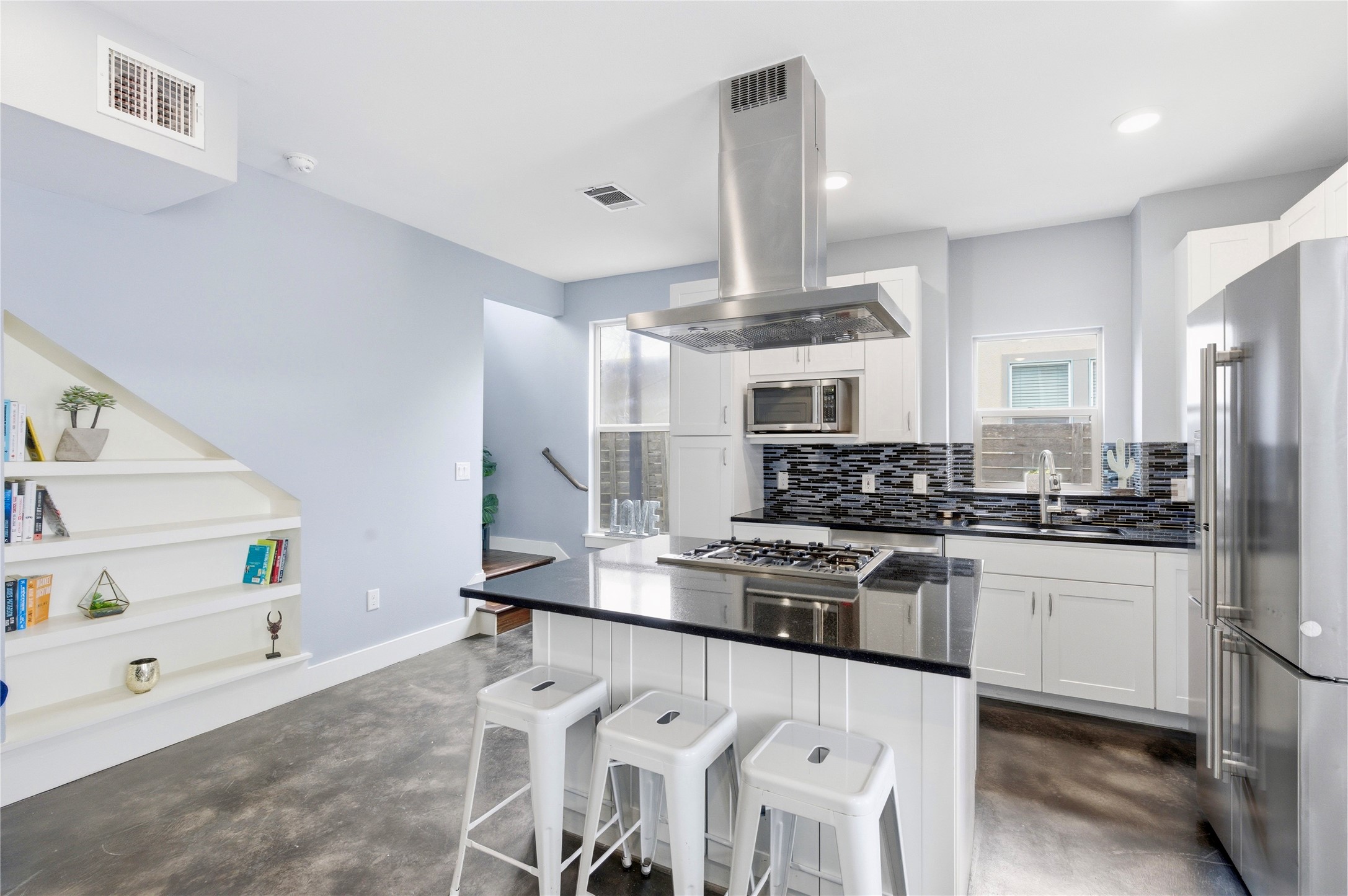 2202 Willow Street, Unit B Austin, TX 78702 - Photo 5 of 21 Kitchen with concrete floors, stainless steel appliances, island range hood, and a breakfast bar area