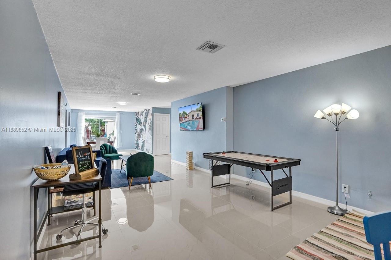 208 Southwest 2nd Avenue Hallandale Beach, FL 33009 - Photo 11 of 28 a living room with furniture and a chandelier