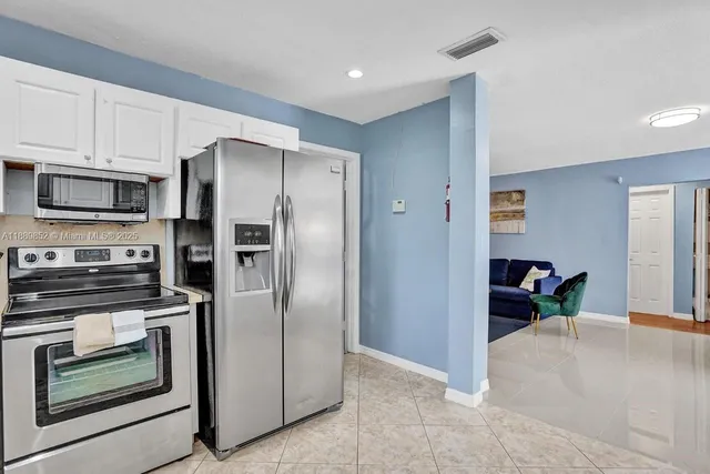 a kitchen with stainless steel appliances granite countertop a refrigerator and a stove top oven