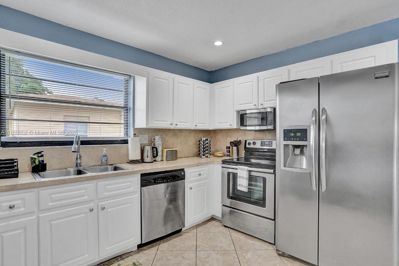 208 Southwest 2nd Avenue Hallandale Beach, FL 33009 - Photo 23 of 28 a kitchen with a refrigerator sink and microwave