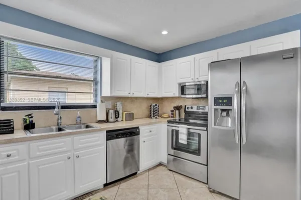 a kitchen with a refrigerator sink and microwave
