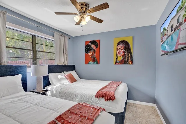 a bedroom with two beds and a large window