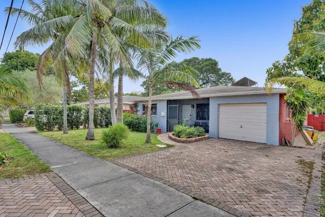 a front view of a house with a yard and potted plants